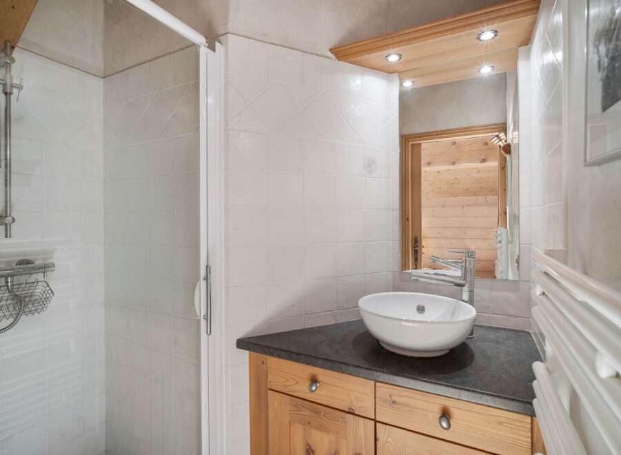 This charming bathroom features a modern design with a sleek countertop and a stylish vessel sink.