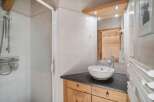 This charming bathroom features a modern design with a sleek countertop and a stylish vessel sink.