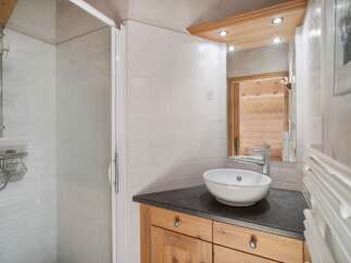 This charming bathroom features a modern design with a sleek countertop and a stylish vessel sink.