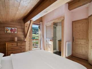 Experience the charm of this cozy bedroom, featuring stunning wooden accents and a serene ambiance.
