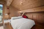 Experience the charm of this cozy bedroom featuring a wooden ceiling and walls, creating a warm and inviting atmosphere.