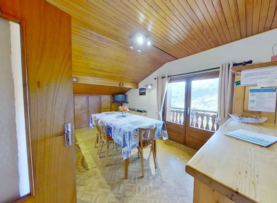 This charming property boasts a cozy dining area with a wooden ceiling and a table set for a delightful meal.