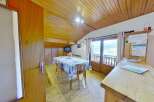 This charming property boasts a cozy dining area with a wooden ceiling and a table set for a delightful meal.