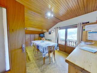 This charming property boasts a cozy dining area with a wooden ceiling and a table set for a delightful meal.