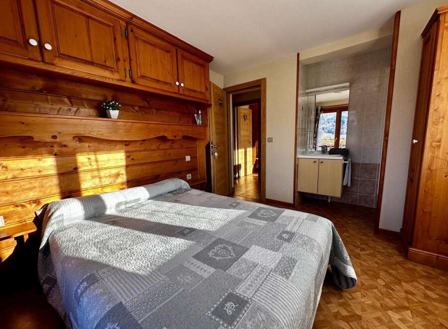Discover the charm of this cozy bedroom, featuring a beautifully crafted wooden headboard and matching cabinetry.