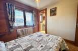 This charming bedroom features a cozy quilt, wooden accents, and a picturesque view through the window.