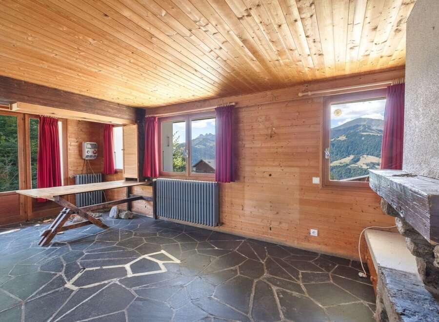 This stunning property boasts a unique interior with wooden paneling and a stone floor, creating a warm and inviting atmosphere.