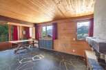 This stunning property boasts a unique interior with wooden paneling and a stone floor, creating a warm and inviting atmosphere.
