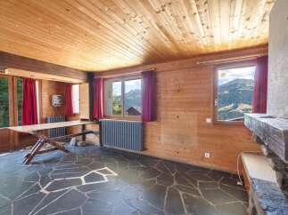 This stunning property boasts a unique interior with wooden paneling and a stone floor, creating a warm and inviting atmosphere.