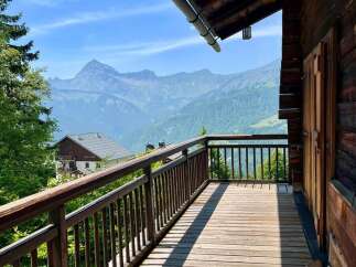 Enjoy breathtaking mountain views from this charming wooden balcony.