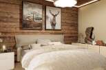 This cozy bedroom features a rustic wooden wall, creating a warm and inviting atmosphere.