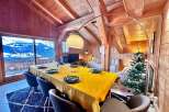 Experience the charm of this stunning chalet, featuring a cozy dining area perfect for gatherings.