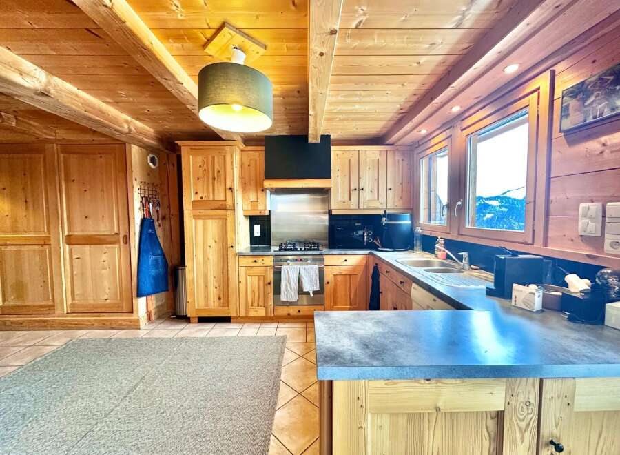 This stunning kitchen boasts a warm, inviting ambiance with its wooden cabinetry and ceiling.
