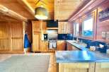 This stunning kitchen boasts a warm, inviting ambiance with its wooden cabinetry and ceiling.