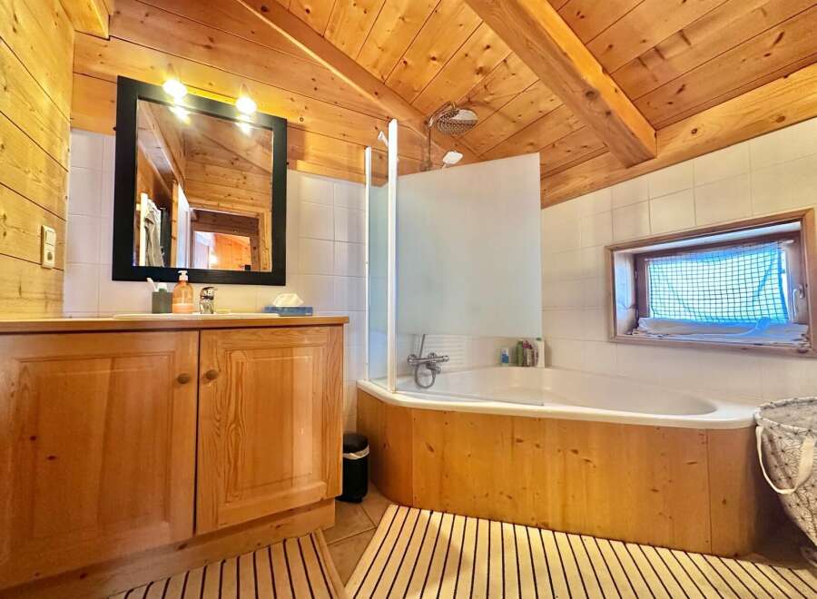 This charming bathroom features a warm, inviting atmosphere with its wooden accents and natural light.