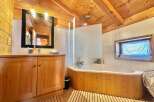 This charming bathroom features a warm, inviting atmosphere with its wooden accents and natural light.