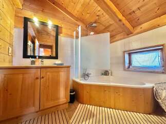 This charming bathroom features a warm, inviting atmosphere with its wooden accents and natural light.