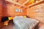 This cozy bedroom features beautiful wooden walls and ceiling, creating a warm and inviting atmosphere.