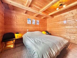 This cozy bedroom features beautiful wooden walls and ceiling, creating a warm and inviting atmosphere.