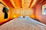Step into a cozy bedroom retreat with warm wooden accents and a charming ambiance.