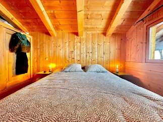 Step into a cozy bedroom retreat with warm wooden accents and a charming ambiance.
