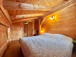 Step into this cozy bedroom featuring stunning wooden accents throughout.