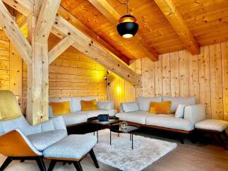 Experience the warmth of this stunning living space, featuring exposed wooden beams and paneling that create a cozy atmosphere.