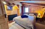 This cozy bedroom features a warm wooden interior, creating a rustic and inviting atmosphere.