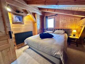 This cozy bedroom features a warm wooden interior, creating a rustic and inviting atmosphere.