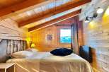 Experience the charm of this cozy bedroom featuring a rustic wooden interior and a comfortable bed.