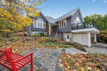 This stunning property boasts a modern design with a beautiful stone facade and a sleek metal roof.