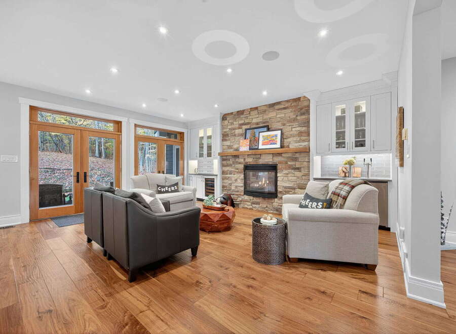 Step into luxury with this stunning living room, featuring a cozy fireplace and elegant hardwood floors.