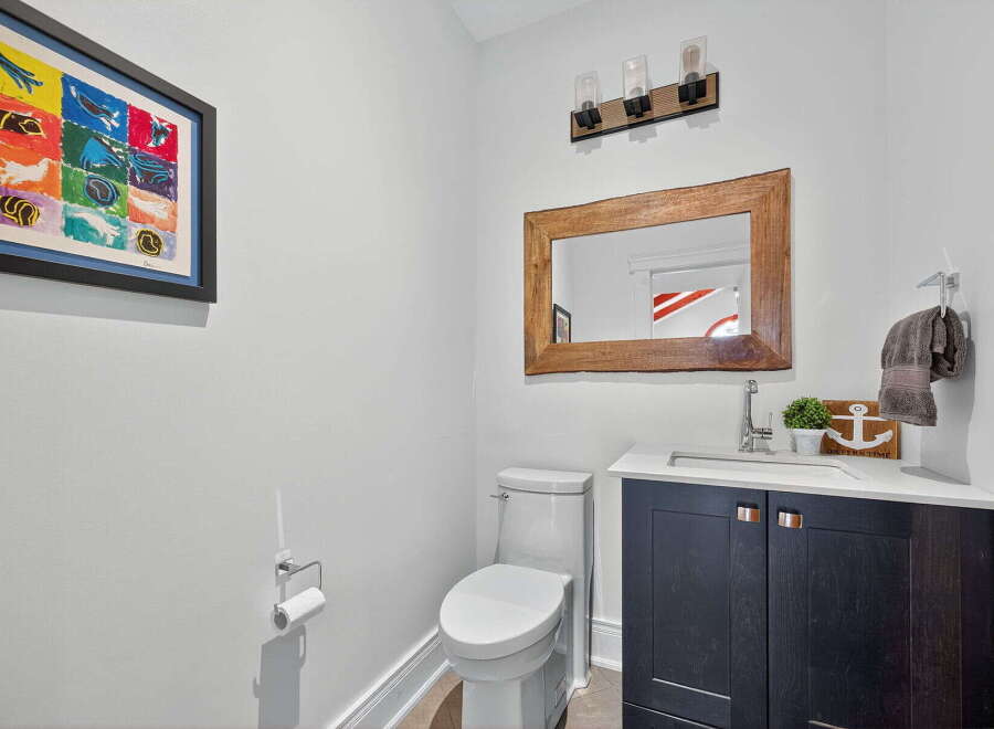 This stylish powder room features a modern vanity with a sleek countertop and dark cabinetry.