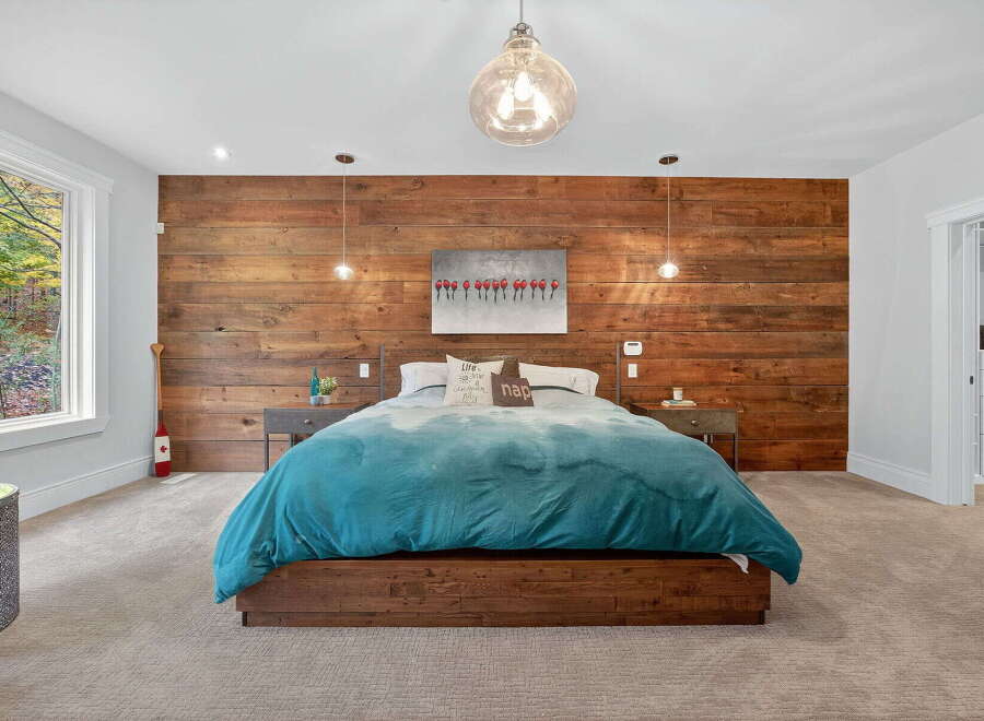 This stunning bedroom features a rustic wood accent wall, creating a warm and inviting atmosphere.