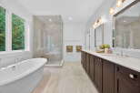 Step into luxury with this stunning bathroom! Featuring a sleek, modern design, this space boasts a spacious walk-in shower, a relaxing soaking tub, and elegant double vanities.