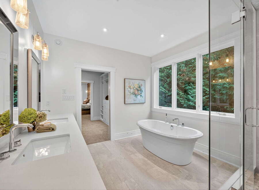 Step into luxury with this stunning bathroom, featuring a freestanding tub and a spacious walk-in shower.