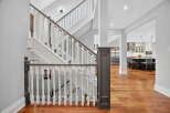 This stunning property features a grand staircase with elegant white balusters and a rich, dark wood handrail, creating a welcoming entrance.