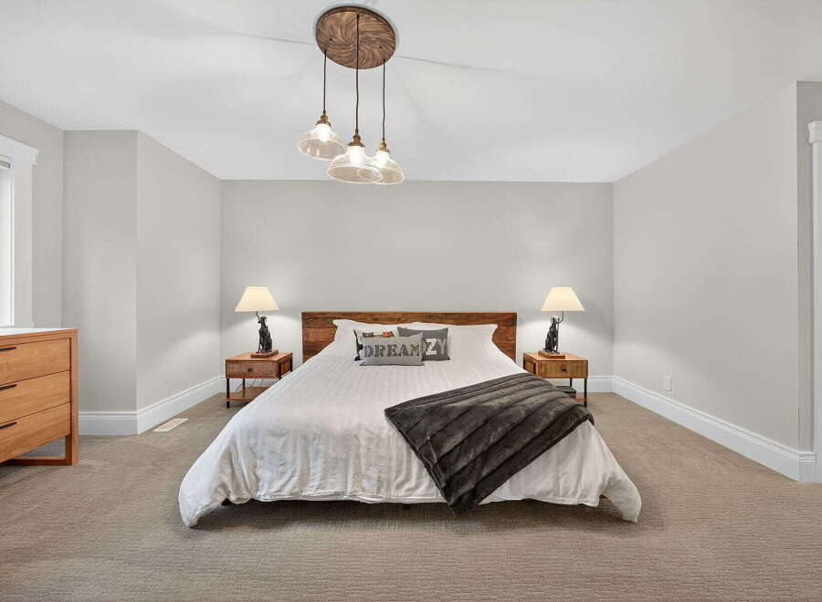 This inviting bedroom boasts a cozy ambiance with its neutral color palette and plush carpeting.