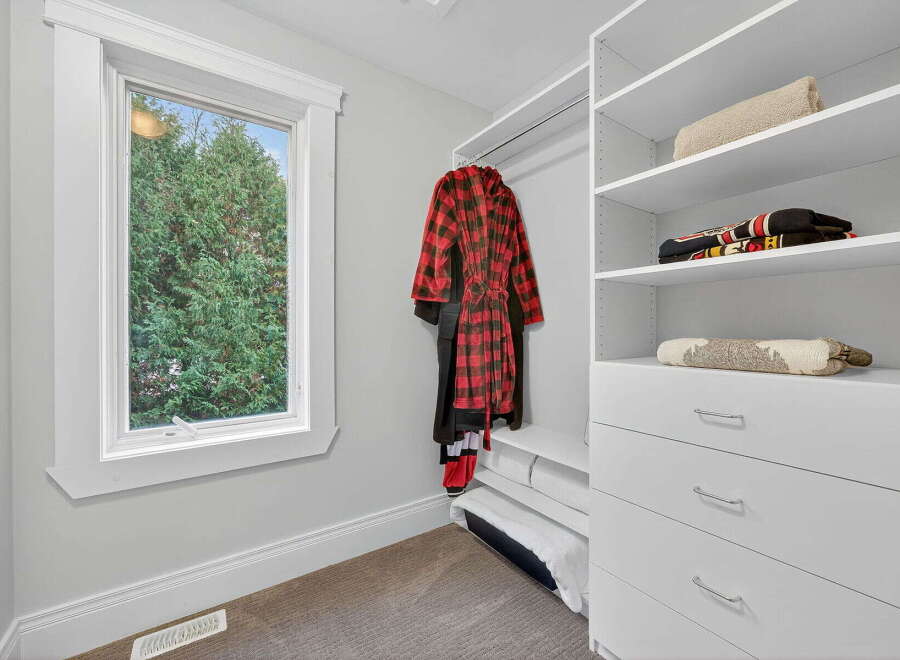 Step into this beautifully organized closet, featuring ample storage and a stylish design.