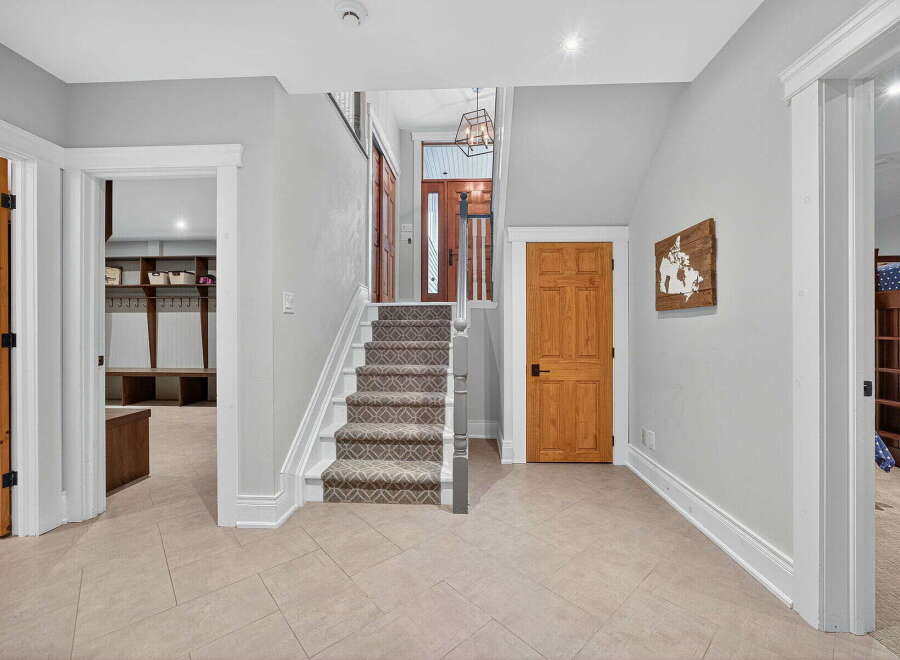Step into this inviting entryway, showcasing a beautiful staircase and stylish flooring.