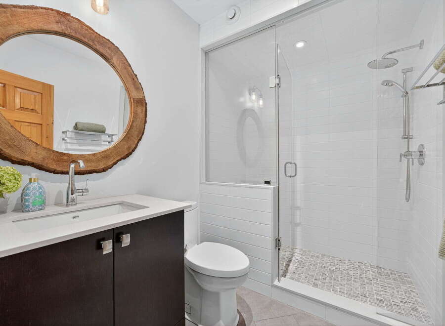 Step into a beautifully designed bathroom featuring a unique wooden-framed mirror, adding a touch of natural elegance.