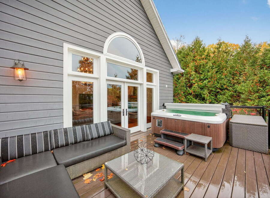 Enjoy luxurious outdoor living with this stunning property! Featuring a spacious deck, a relaxing hot tub, and a comfortable outdoor seating area, this home is perfect for entertaining or unwinding.