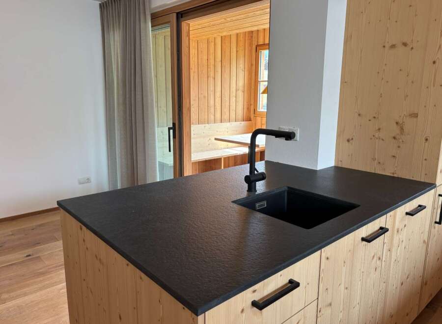 This stunning kitchen boasts a modern design with a sleek black countertop and a stylish black faucet.