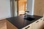 This stunning kitchen boasts a modern design with a sleek black countertop and a stylish black faucet.