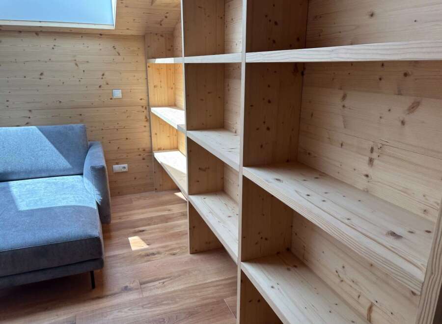 This stunning property boasts a custom-built wooden shelving unit, perfect for displaying your favorite books and decor.