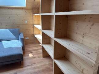 This stunning property boasts a custom-built wooden shelving unit, perfect for displaying your favorite books and decor.