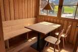 This charming dining area features a cozy wooden bench and a stylish wooden table, perfect for enjoying meals.