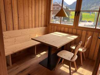 This charming dining area features a cozy wooden bench and a stylish wooden table, perfect for enjoying meals.