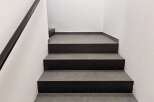 This property features a modern staircase with dark gray steps and a sleek black handrail.