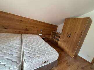 This cozy bedroom features a modern design with a wooden accent wall and a comfortable bed.